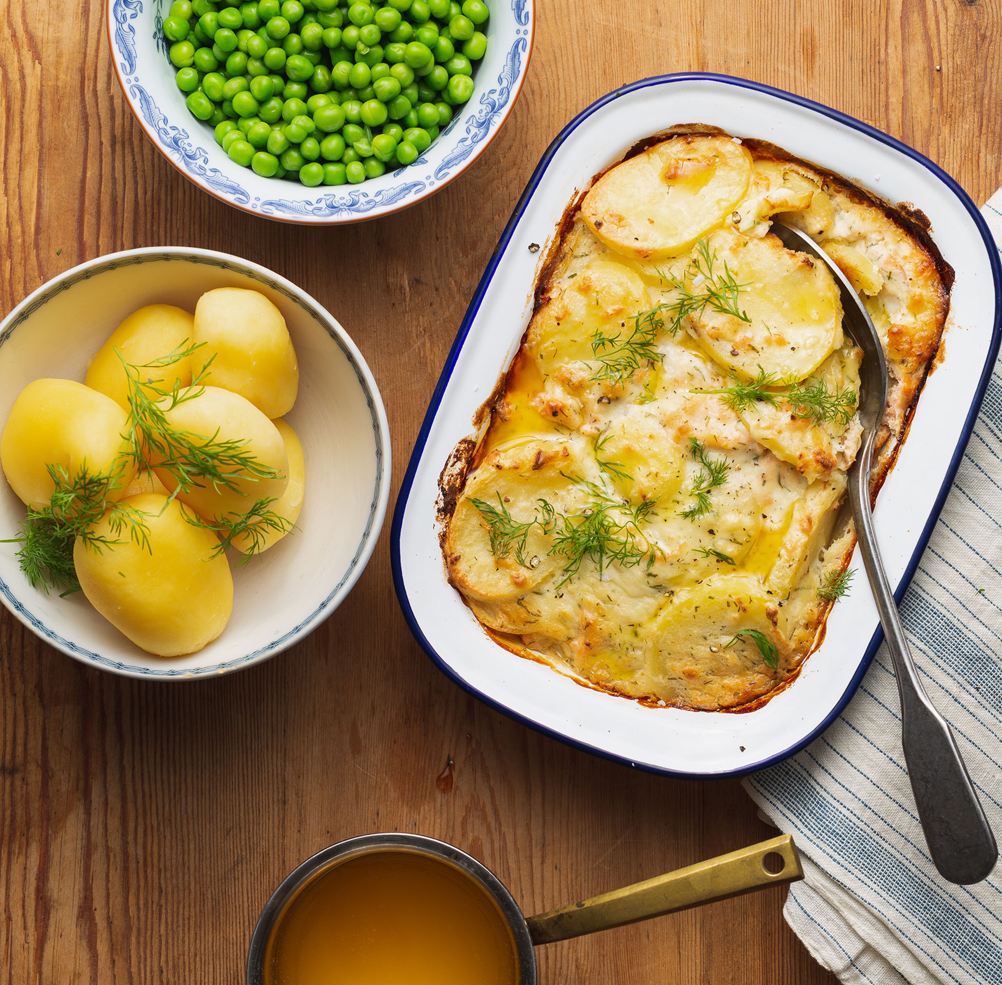 Bild på ett serveringsförslag med fiskpudding, kokt potatis, gröna ärter och skirat smör